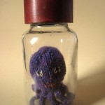 Hand knitted mini octopus sculpture in glass jar