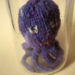 Hand knitted mini octopus sculpture in glass jar