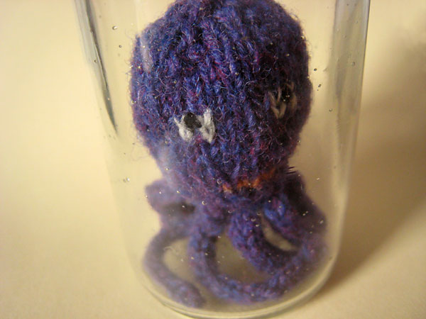 Hand knitted mini octopus sculpture in glass jar