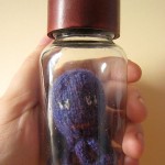 Hand knitted mini octopus sculpture in glass jar