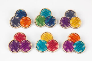 6 multicolour stitched yarn balls on wood