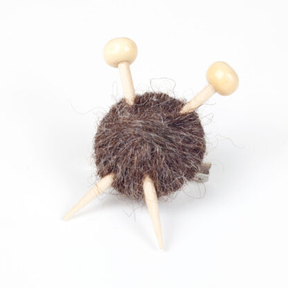 ball of wool with 2 knitting needles on a white background