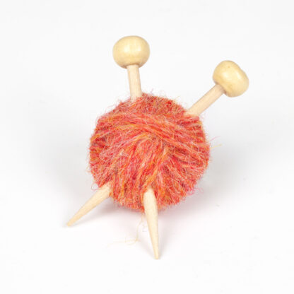 Orange ball of wool with 2 knitting needles on a white background