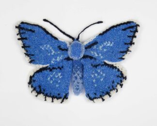 Knitted blue butterfly with black and white details